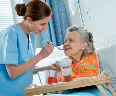 senior woman 90 years old being fed by a nurse